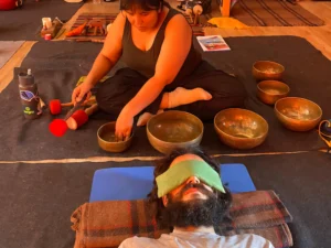 Tibetan singing bowls being played with a mallet during a sound therapy session in Rishikesh
