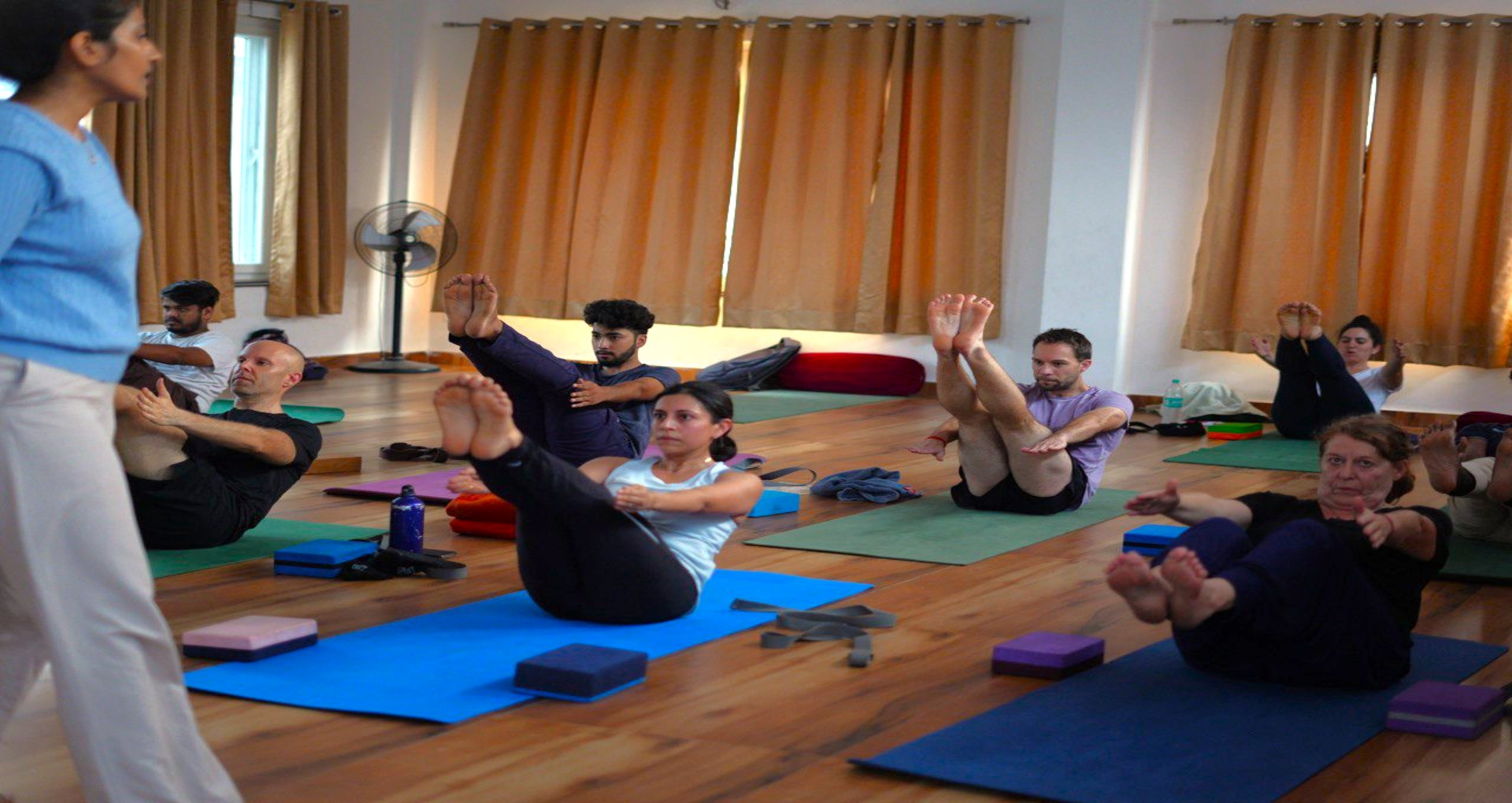 Outdoor retreat group meditating by the river Ganga