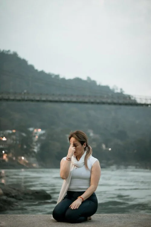 Yoga practitioner meditating near Ganga beach during Jeevatman Yogshala retreat in Rishikesh