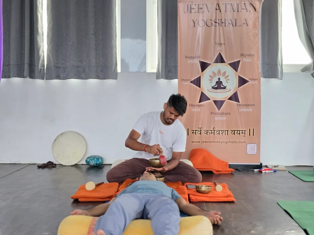 Sound healing practitioner placing a singing bowl on the body during a session