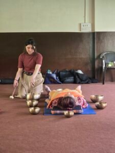 Sound bath therapy session with singing bowls placed around participant
