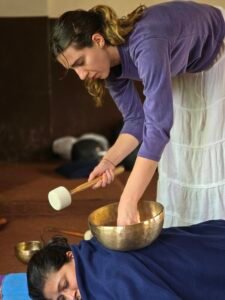 Practitioner performing sound healing using Tibetan singing bowls