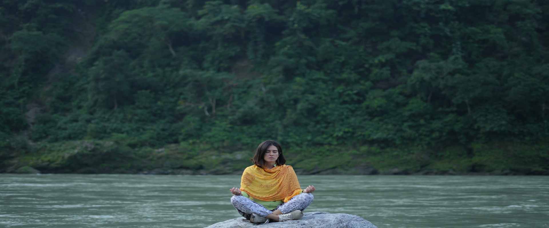 Meditating near the ganga River during yoga retreat at Jeevatman Yogshala, Rishikesh - experience peace, mindfulness and inner balance